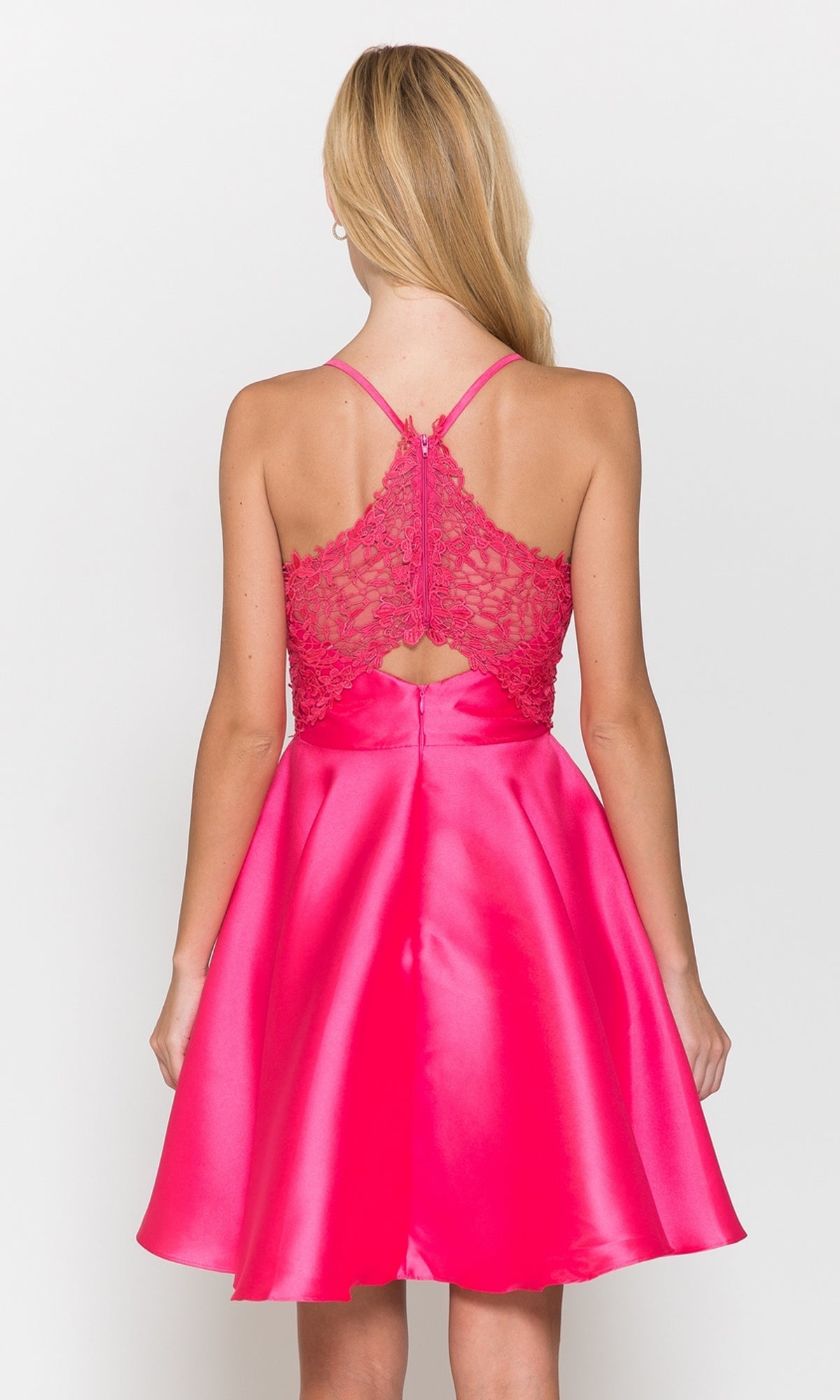 A woman models the Lace-Back Short A-Line Homecoming Dress 8698 in bright pink, featuring a flared satin skirt and lace back, shown from behind against a plain background.